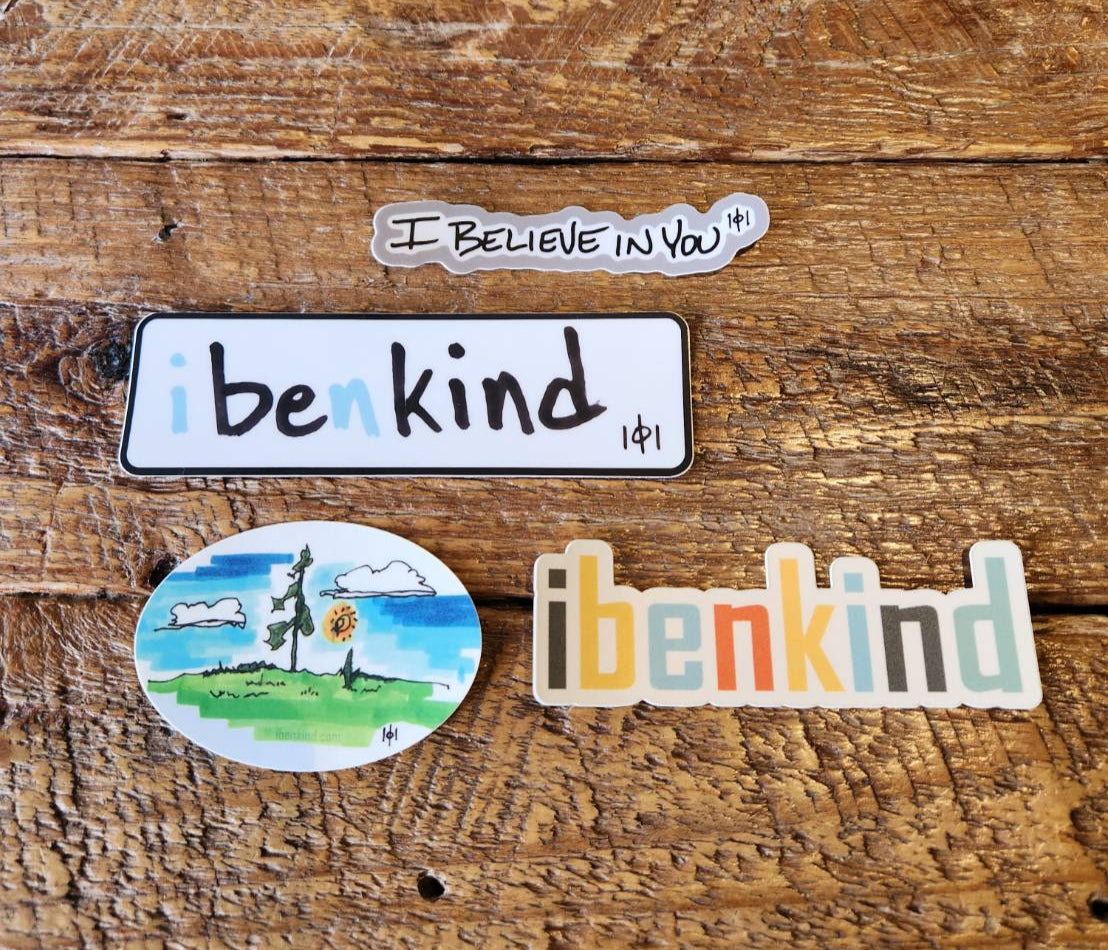 Four stickers on a wooden surface, including 'I believe in you', 'i ben kind', and 'benkind'.
